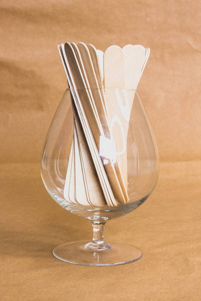 Voskové dřevěné obracečky ve sklenici na hnědém pozadí. Vosové epilační nástroje. Samoobslužný vosk equepment - Fotografie, Obrázek