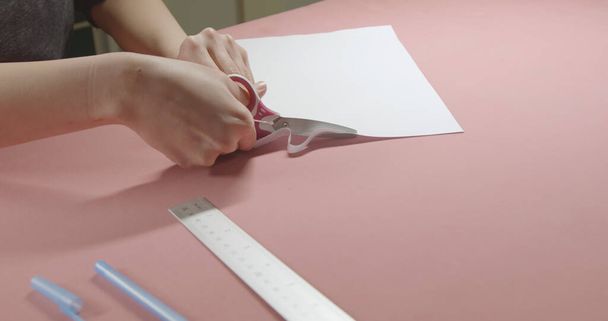 girl cuts paper with scissors - Фото, зображення