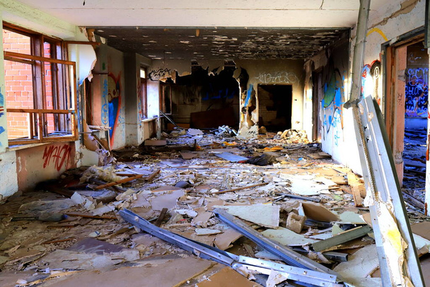 放棄された住宅建築、オフィス、学校の汚いインテリア。廃墟の部屋のアパートだ。ウクライナ東部ドンバスでの戦争中の破壊 - 写真・画像