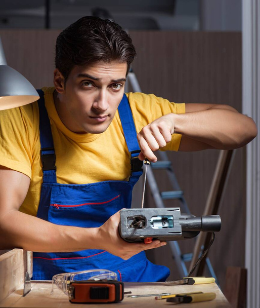 Trabajador que trabaja en taller de reparación en concepto de carpintería - Foto, Imagen