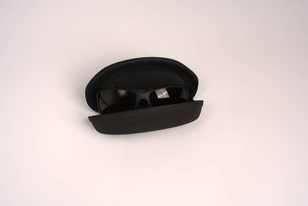Sunglasses in a black eyeglass case on a white background. - Foto, immagini