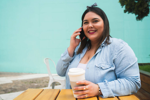 Young plus size woman talking on the phone. - Фото, изображение