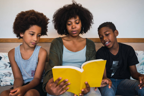 Afro mother reading a book to her children. - Photo, Image