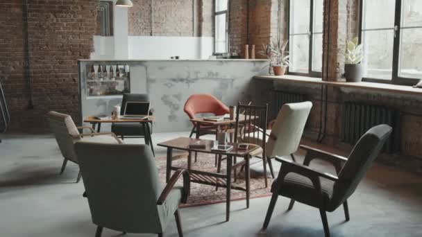 No people aerial shot of stylish loft workspace for business people and freelancers with designer chairs and wooden tables with gadgets and stationery on them - Footage, Video