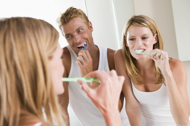 Couple in bathroom brushing teeth - Фото, зображення