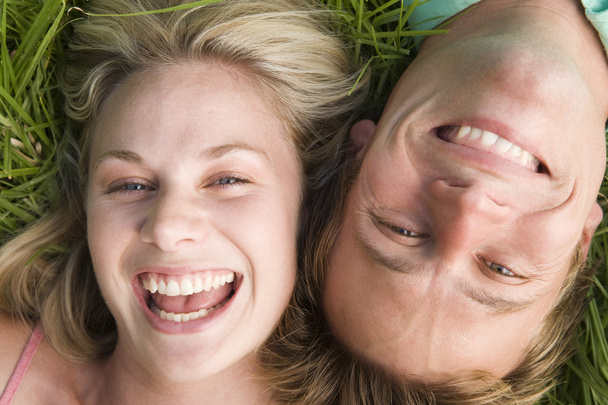 Couple lying in grass smiling - Foto, immagini