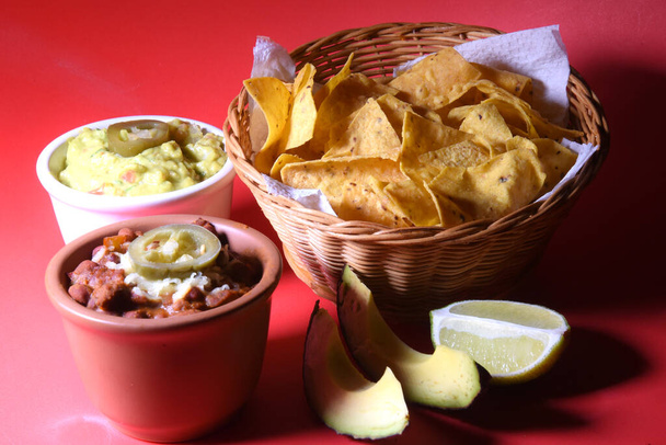 вкусный мексиканский гуакамоле с чили quesadillas на красном фоне. - Фото, изображение