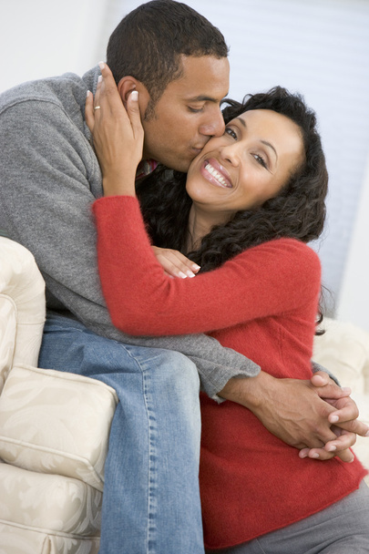 Couple in living room kissing and smiling - Photo, image