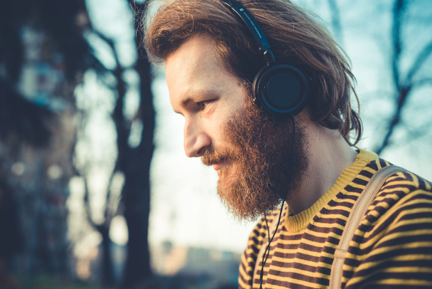 młody przystojny stylowy mężczyzna słuchania muzyki brodaty  - Zdjęcie, obraz
