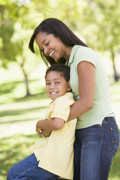 Woman and young boy outdoors embracing and smiling - Foto, imagen