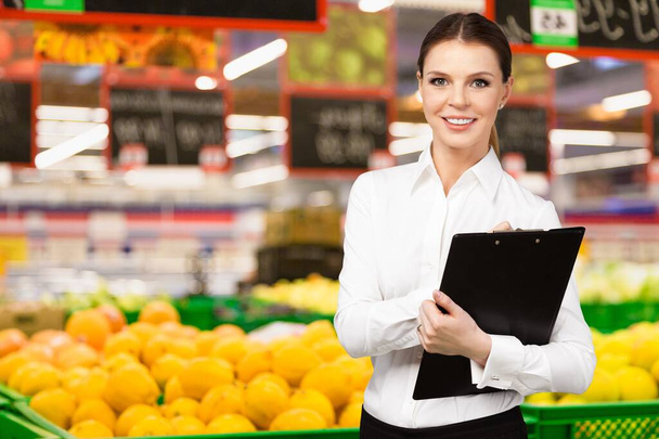 Beautiful young woman working in a grocery store - Zdjęcie, obraz