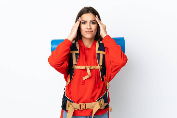 Mladý kavkazský horolezec dívka s velkým batohem izolované na bílém pozadí nešťastné a frustrovaný s něčím. Negativní výraz obličeje - Fotografie, Obrázek