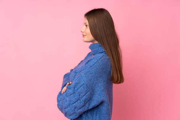 Teenager caucasian girl isolated on pink background in lateral position - Φωτογραφία, εικόνα
