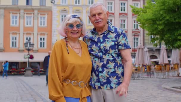 Пожилая стильная пара туристов мужчина женщина смотрит одобрительно на камеру показывая жест ОК, как знак - Кадры, видео