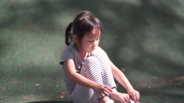 poražené asijské čínské dítě sundavat boty a setřást oblázky - Záběry, video