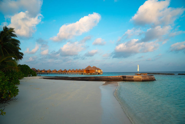 Maldivler cenneti manzarası. Su bungalovlu deniz burnu, güzel turkuaz deniz ve lagün suları, tropikal doğa. Egzotik tropikal ada plajı. - Fotoğraf, Görsel