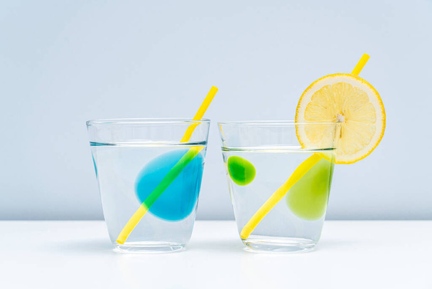 Two healthy lemonades are placed in the glass. Pure water in two clear glasses. - Fotó, kép