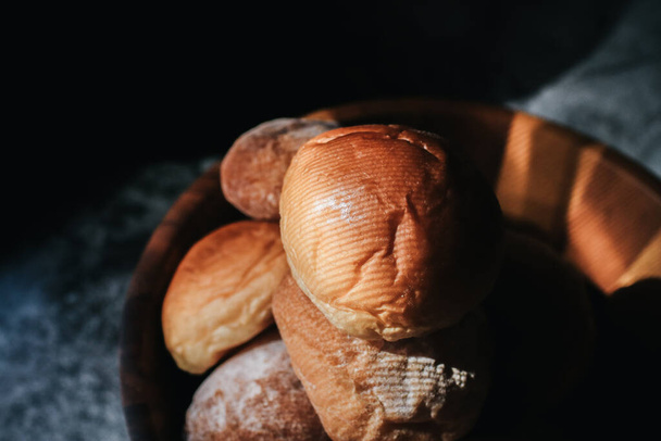 Homemade sourdough and bread bun. Freshly baked bread. Organic whole-wheat loaves. Simple breakfast on grey concrete background.  - Фото, зображення