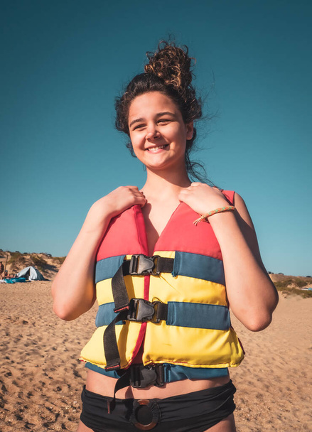 Teenage girl in waistcoat enjoying water activities on banana boat at the black sea. - Zdjęcie, obraz