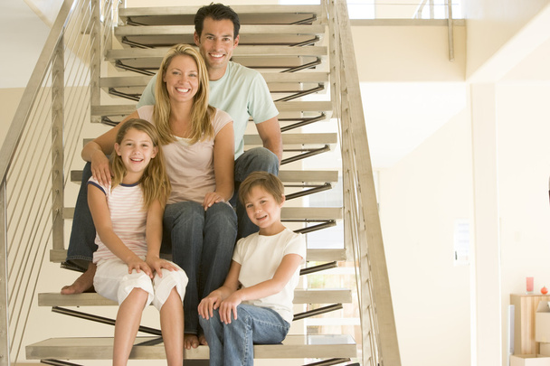 Familie sitzt lächelnd auf Treppe - Foto, Bild