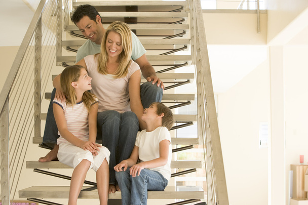 Family sitting on staircase smiling - Foto, immagini
