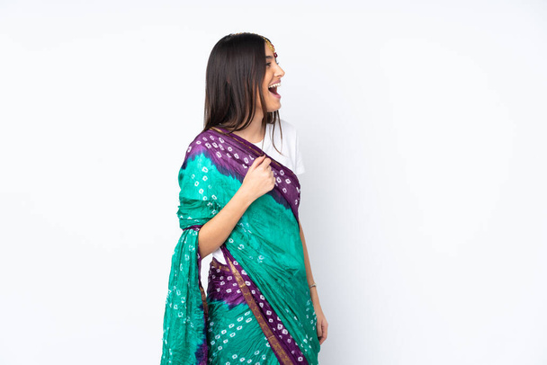 Молодая индийская женщина на белом фоне смеется в боковом положении - Фото, изображение