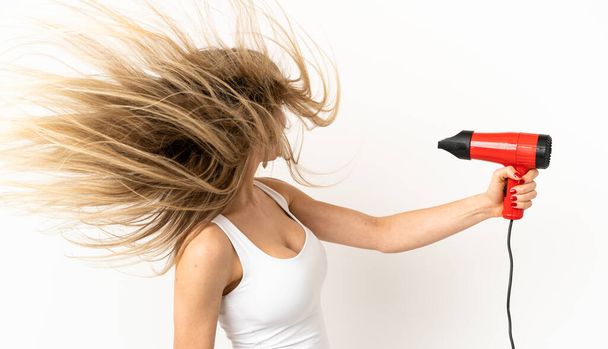Woman with a hairdryer over isolated background - Foto, Imagem