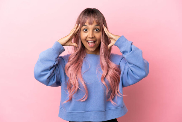 Young mixed race woman with pink hair isolated on pink background with surprise expression - Foto, Imagen