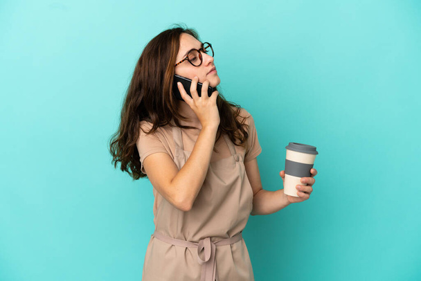 Restaurantkellner mit Kaffee zum Mitnehmen und einem Handy - Foto, Bild