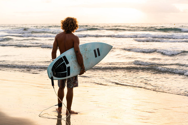 Jovem caucasiano levantar cedo para fazer surf ao nascer do sol - Foto, Imagem