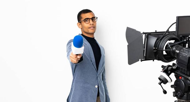 Reportero afroamericano sosteniendo un micrófono y reportando noticias sobre fondo blanco aislado - Foto, Imagen
