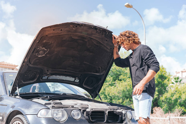 Jeune homme caucasien essayant de réparer une panne dans sa voiture - Photo, image