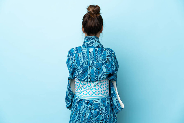 Žena na sobě kimono přes izolované pozadí v zadní poloze - Fotografie, Obrázek