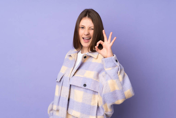 Teenager kavkazské dívka izolované na fialovém pozadí ukazující ok znamení s prsty - Fotografie, Obrázek
