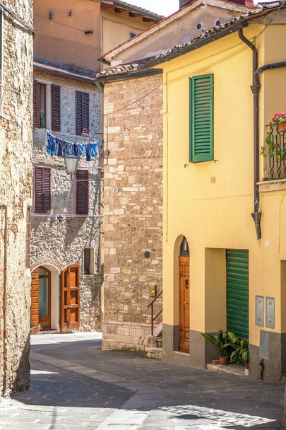 Asciano town, Siena Province, Tuscany, Italy: 19 June, 2019 -  view of narrow streets of the town, no people walking around  during midday siesta  - Fotoğraf, Görsel