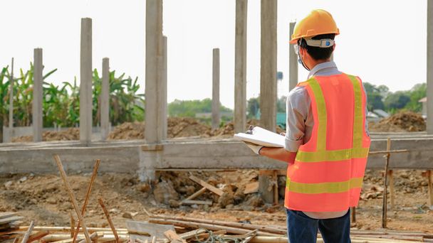 Engineer contractor man work safety industry project, check house plan design and investigating the size and quality in building construction structures site. - Photo, Image