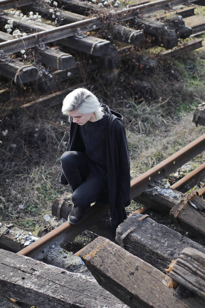 bel homme au look noir total posant sur la gare abandonnée - Photo, image