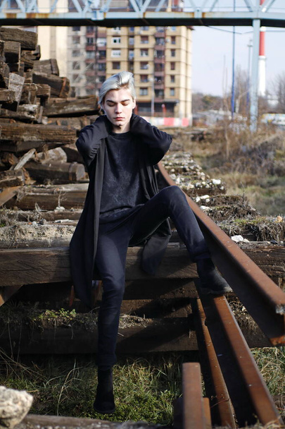 handsome man in total black look posing on abandoned railway station - Photo, Image
