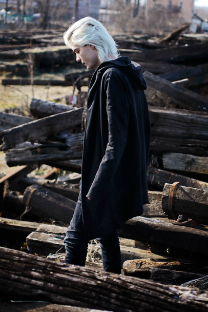 hombre guapo en total negro mirada posando en abandonado estación de tren - Foto, Imagen