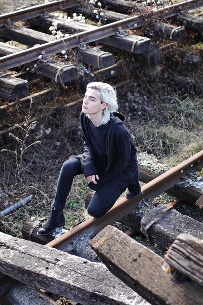 handsome man in total black look posing on abandoned railway station - Photo, Image
