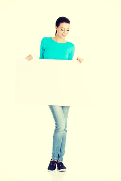 Portrait young happy woman with blank board - Фото, изображение
