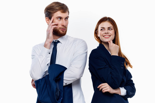 νεαρό ζευγάρι που φοράει κοστούμια στέκεται δίπλα στους συναδέλφους εργασίας επικοινωνώντας οικονομικά - Φωτογραφία, εικόνα