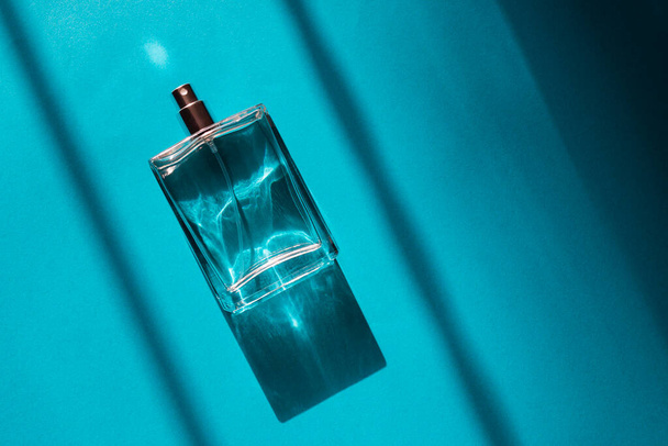 Frasco transparente de perfume con spray sobre fondo azul - Foto, Imagen