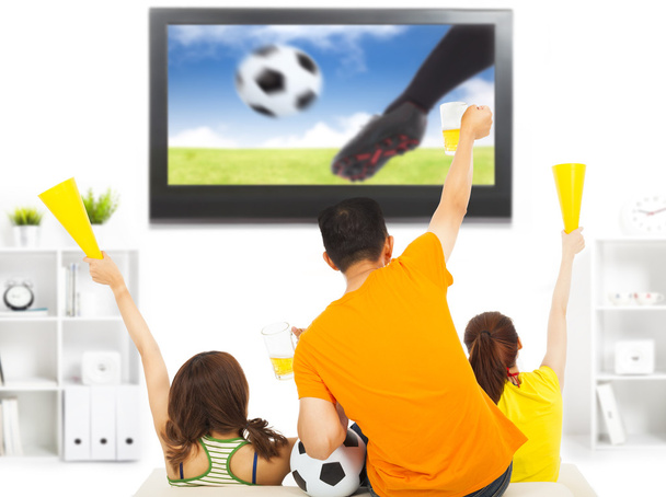 молодые фанаты смотрят футбол и вопят дома
 - Фото, изображение