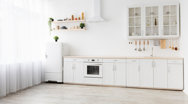 Tamir sonrası minimum konforlu İskandinav iç mekanı. Beyaz mutfak mobilyaları, basit yemek odasındaki buzdolabı, panorama - Fotoğraf, Görsel