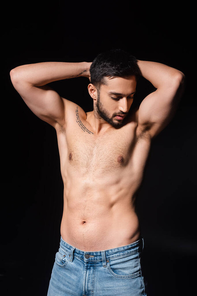 Shirtless and bearded man posing isolated on black  - Фото, изображение