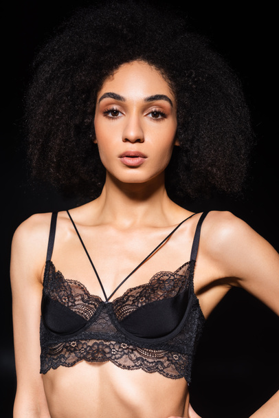 African american woman in lace bra looking at camera isolated on black  - Foto, afbeelding