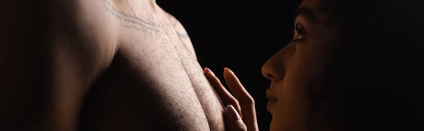 Side view of african american woman touching chest of boyfriend isolated on black, banner  - Fotoğraf, Görsel