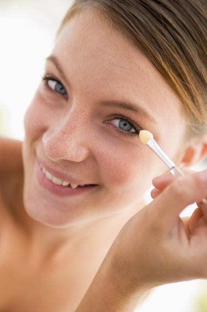 Woman with eyeshadow applicator smiling - Foto, Imagen