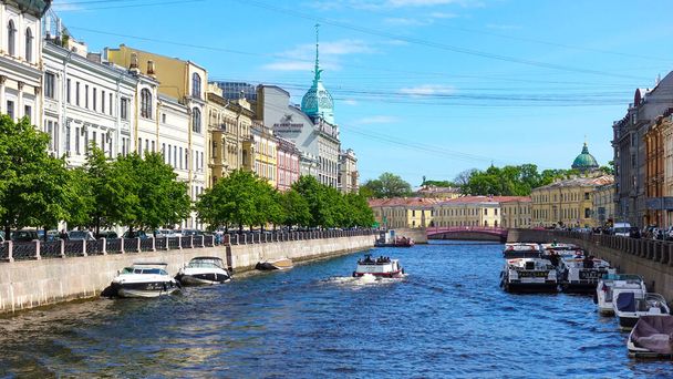Moika river, pleasure ships, embankment with a red bridge. Russia, Saint Petersburg June 2021 - Φωτογραφία, εικόνα
